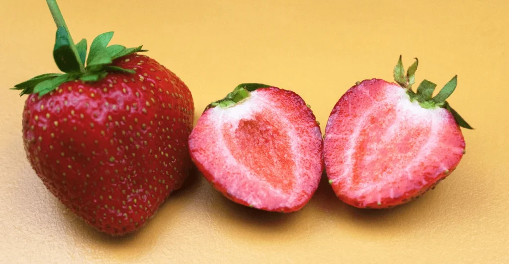 Side-by-side comparison of small and large strawberries highlighting differences in size and color