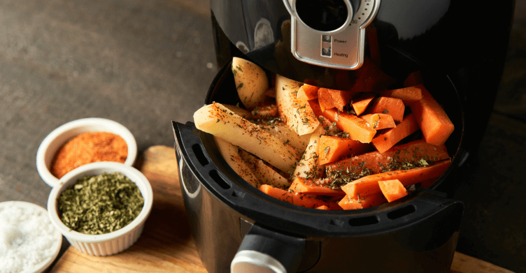 Overcrowded air fryer basket with overlapping chicken wings, showing poor airflow and uneven cooking.
