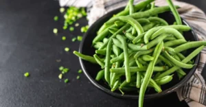 Blanched green beans being packed into freezer bags to keep them fresh for months