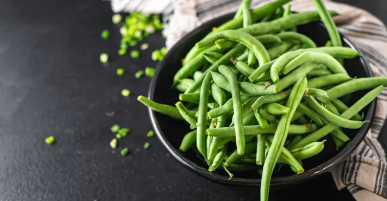 Blanched green beans being packed into freezer bags to keep them fresh for months